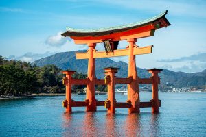 A very large vermillion torii (shrine gate) rising out of the sea