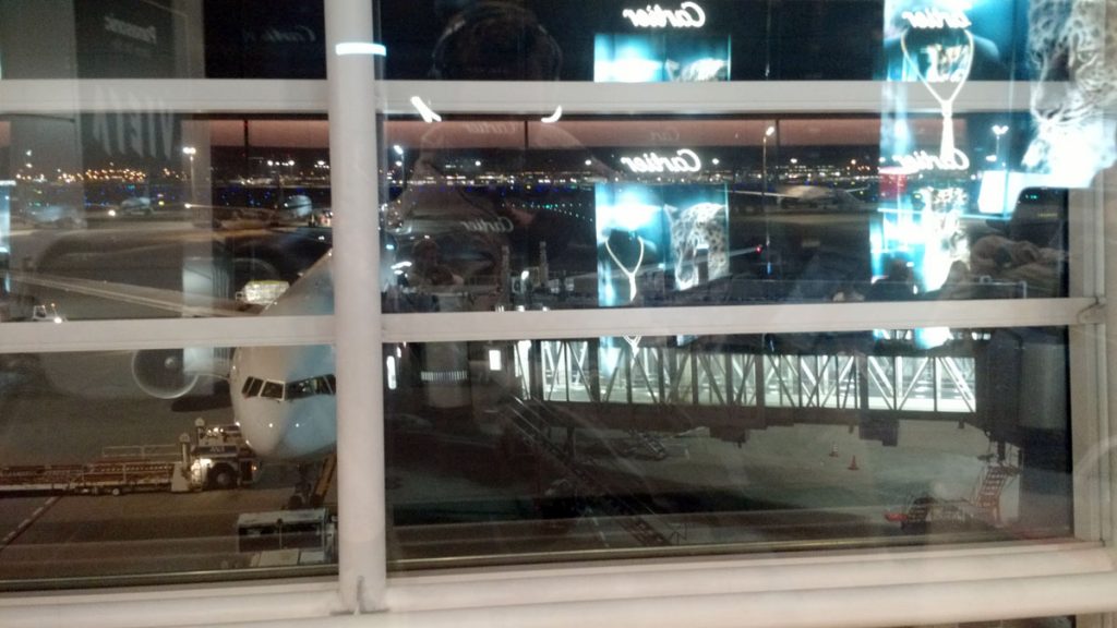 View through a window - Cartier store reflected in the glass, and planes behind.