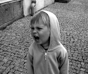 Small child in a hoodie shouting.