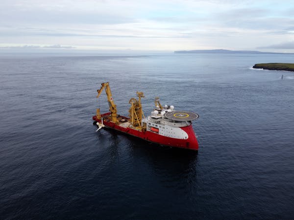 A ship lowing a turbine into the water