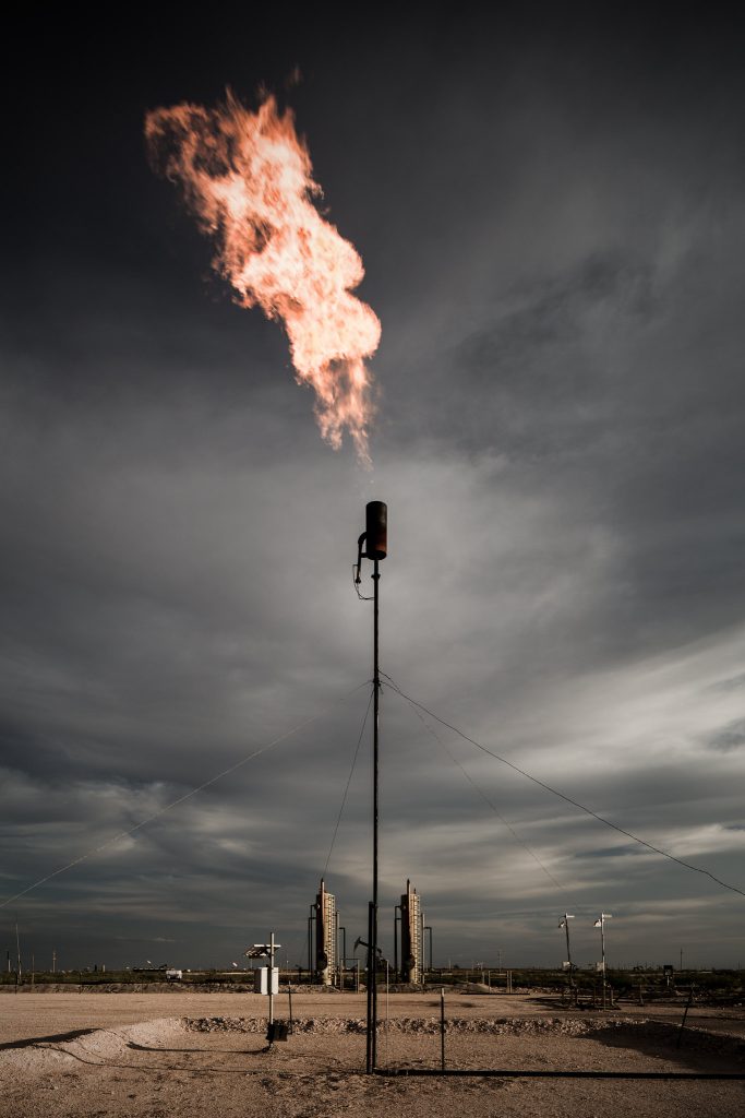 Atmospheric view of gas being flared into an evening sky.